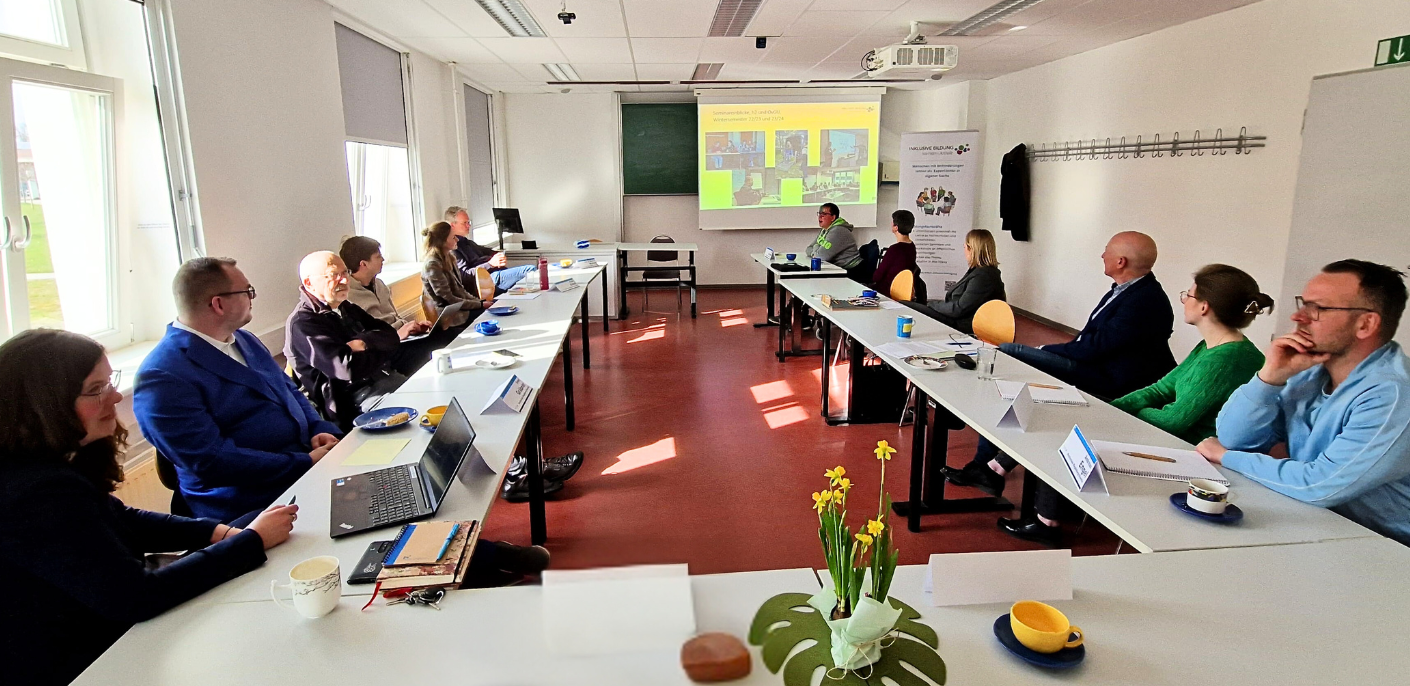 U-förmige Tisch Formation. Viele Menschen sitzen an der Tischformation und schauen sich eine Präsentation an.