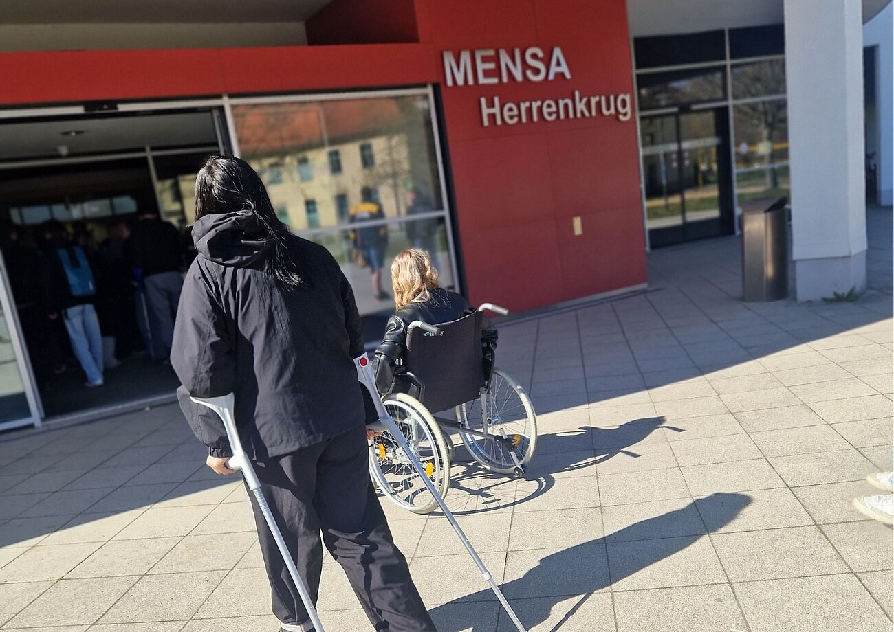 zwei mobil eingeschränkte personen vor der Mensa Herrenkrug in Magdebur
